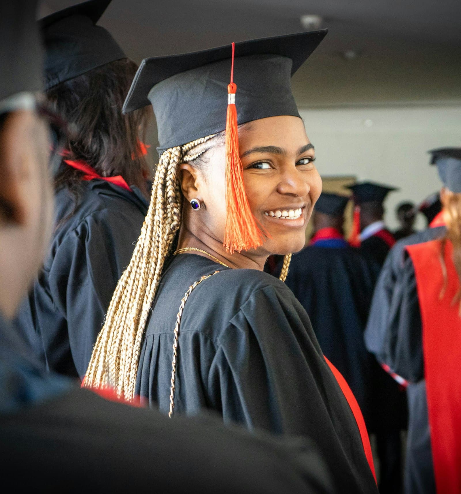 Smiling graduate in cap and gown at her graduation ceremony