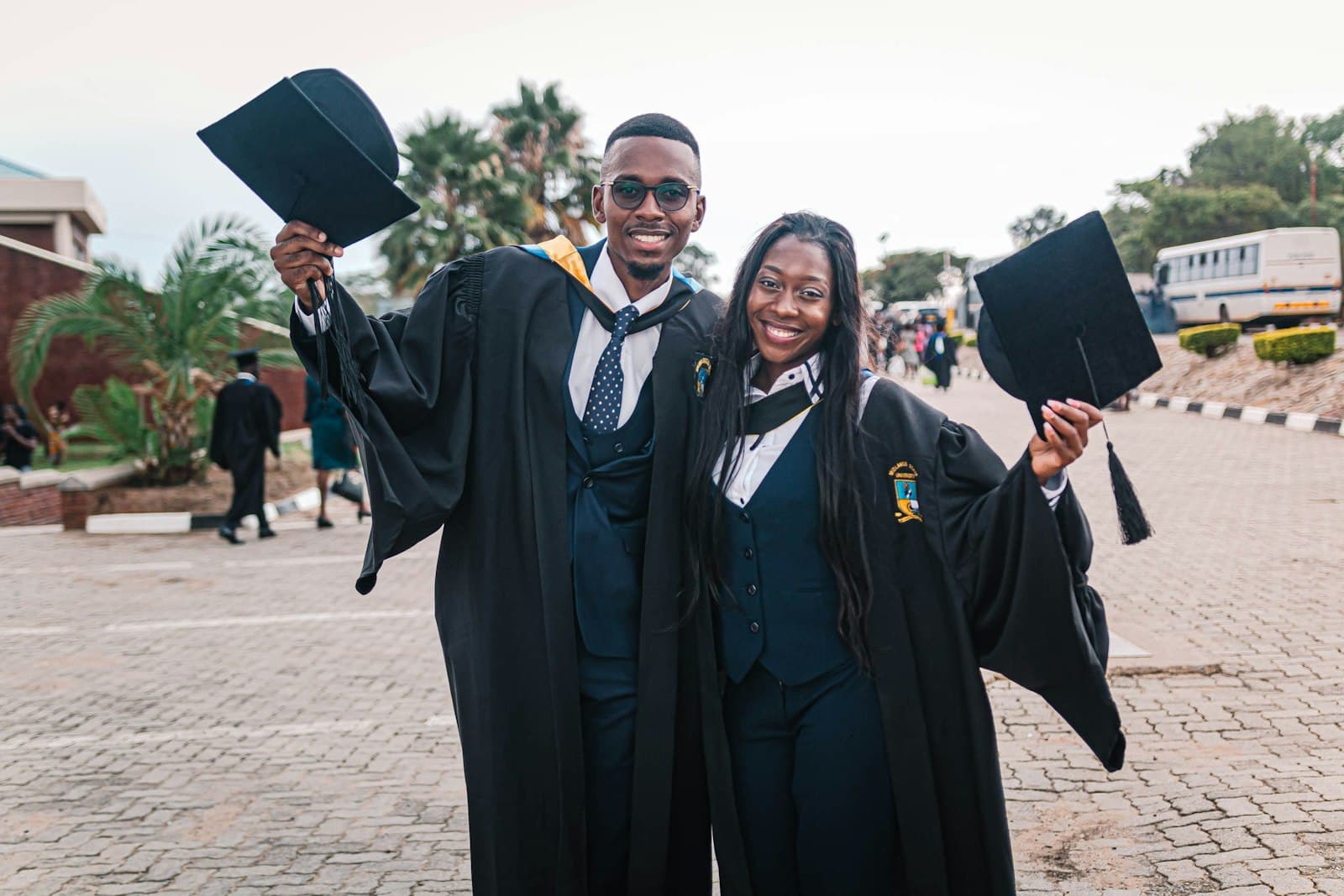 Two graduates celebrating with their caps raised
